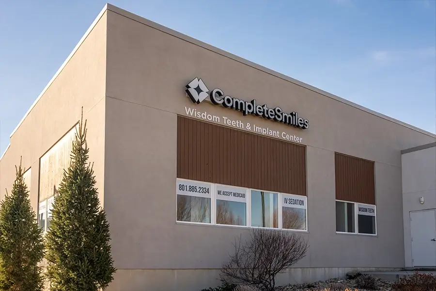 The Complete Smiles Mountain View office, a tan building with the Wisdom Teeth & Implant Center sign | Complete Smiles-Cottonwood Heights-Mountain View-Redwood-Utah