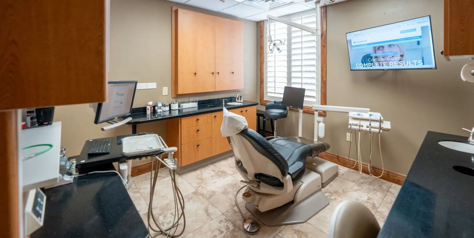 Cottonwood Heights treatment room with a dental chair and wall-mounted screen | Complete Smiles-Cottonwood Heights-Mountain View-Redwood-Utah