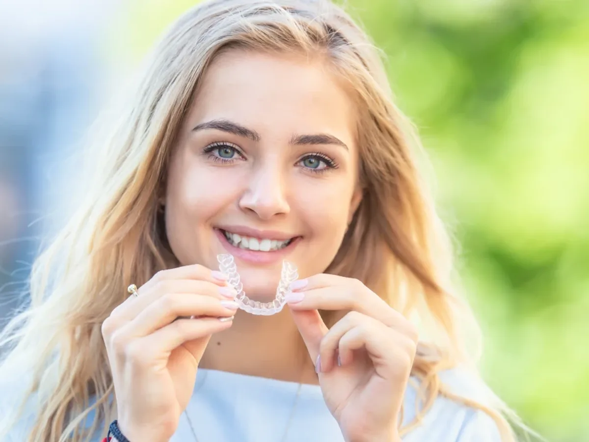 A young woman holding up a clear aligner tray | Complete Smiles-Cottonwood Heights-Mountain View-Redwood-Utah