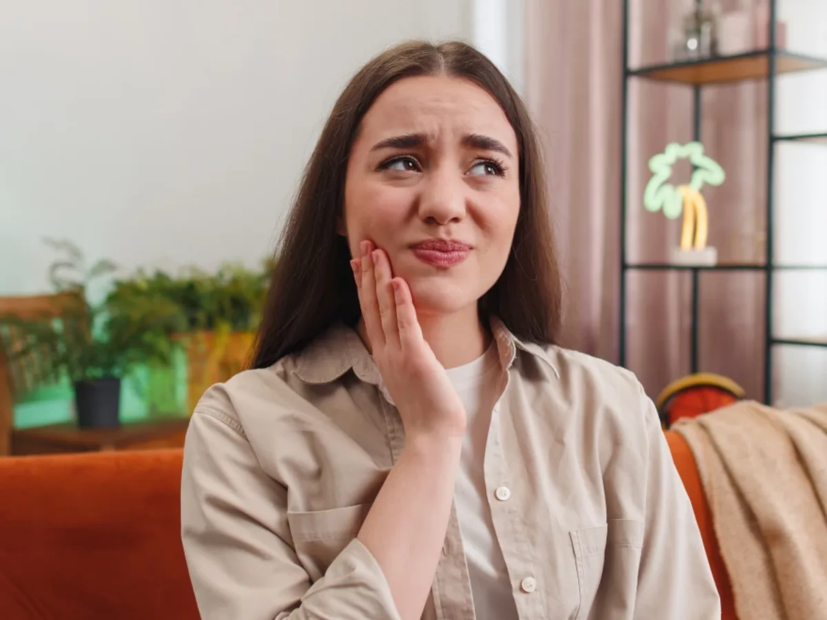 A woman holding her cheek in pain before an emergency visit | Complete Smiles-Cottonwood Heights-Mountain View-Redwood-Utah